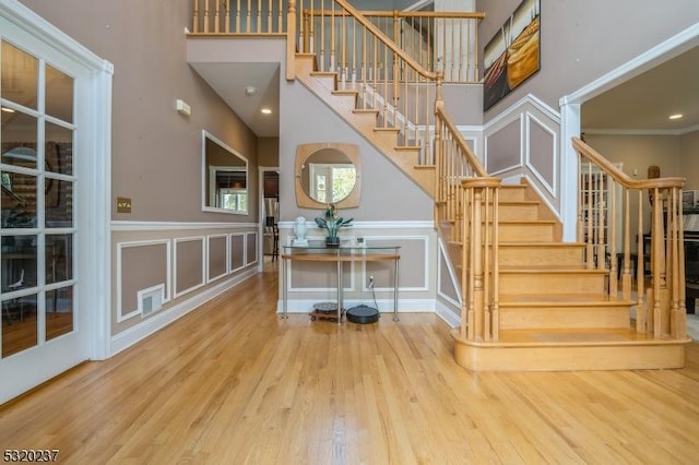20 Crestview Ln, Sparta Twp, NJ 07871 - stairs with wood finished floors, a decorative wall, a high ceiling, and wainscoting