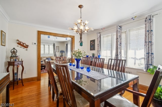 dining room featuring crown molding, hardwood / wood-style flooring, and plenty of natural light