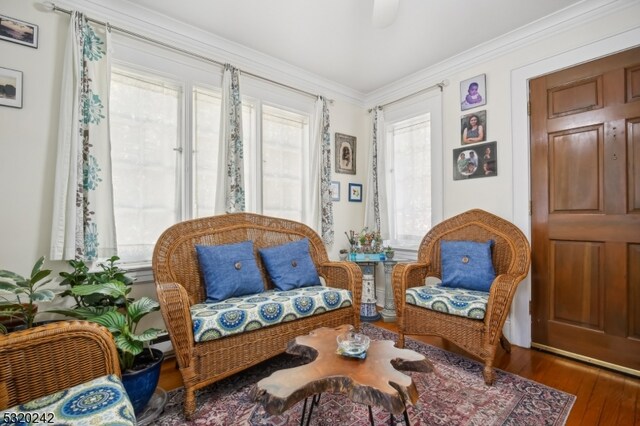 sitting room featuring ornamental molding, hardwood / wood-style floors, and a healthy amount of sunlight