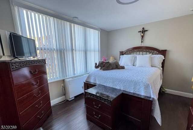 bedroom featuring radiator heating unit and dark hardwood / wood-style flooring