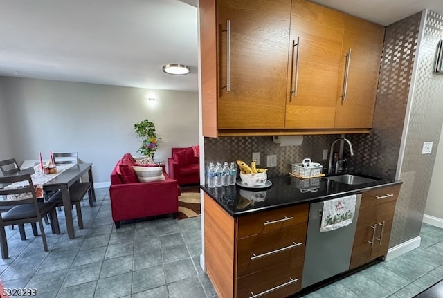 kitchen with dishwasher, tasteful backsplash, sink, and dark tile patterned floors