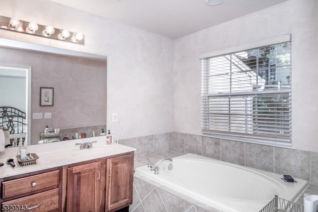 bathroom featuring vanity and tiled bath