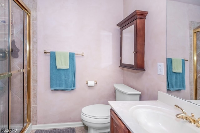 bathroom with vanity, a shower with shower door, toilet, and tile patterned floors