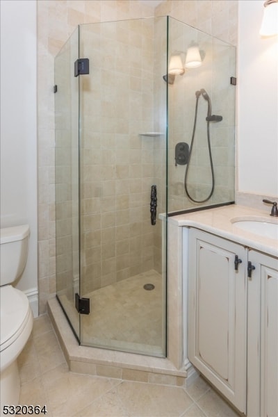 bathroom featuring walk in shower, toilet, vanity, and tile patterned floors