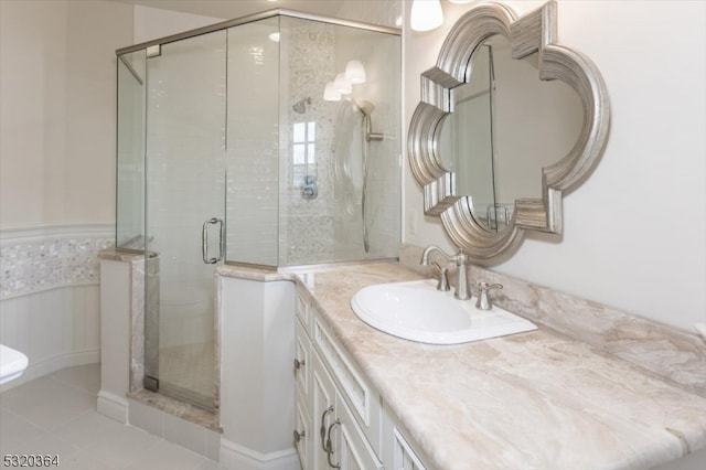 bathroom with tile patterned flooring, vanity, and a shower with door