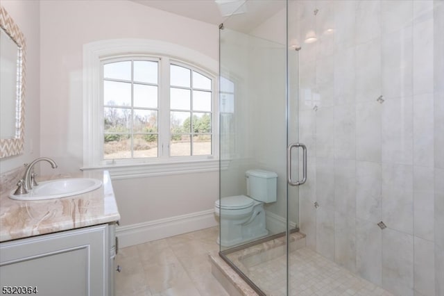 bathroom featuring a shower with shower door, vanity, and toilet