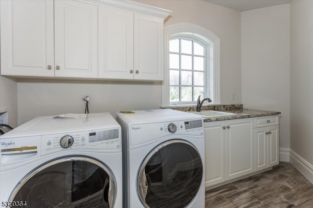 washroom featuring cabinets, dark hardwood / wood-style flooring, sink, and washer and clothes dryer