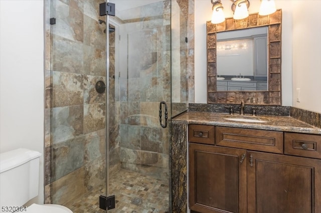 bathroom featuring walk in shower, vanity, and toilet