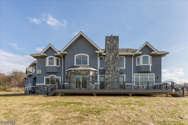 rear view of property featuring a wooden deck and a yard