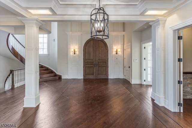 foyer entrance with dark wood-type flooring, crown molding, and decorative columns