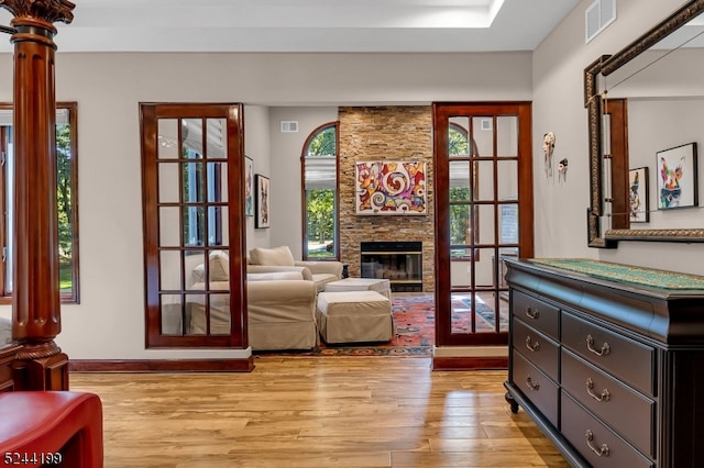 living area with a stone fireplace and light wood-type flooring