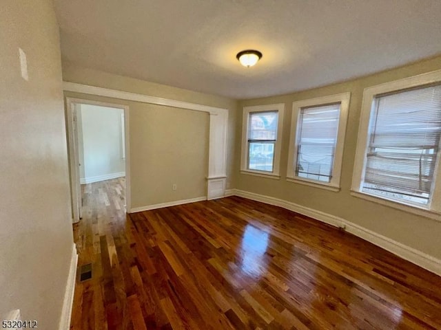 unfurnished room featuring dark wood-type flooring