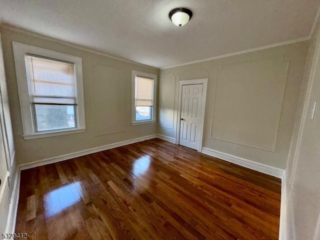 spare room featuring dark hardwood / wood-style floors and ornamental molding