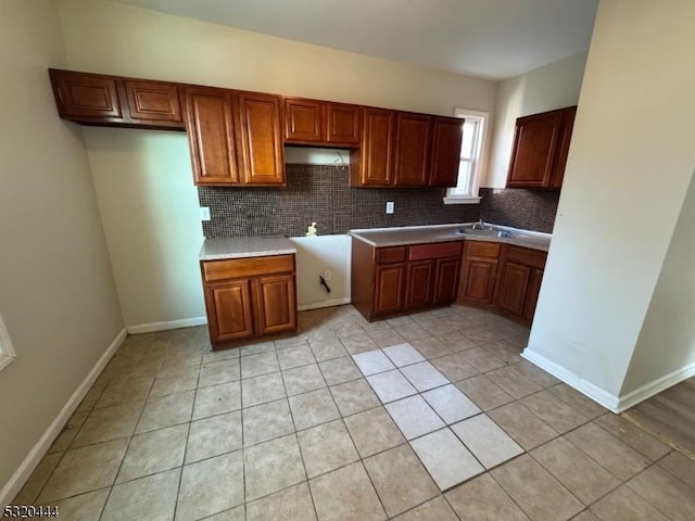 kitchen with decorative backsplash, sink, and light tile patterned flooring