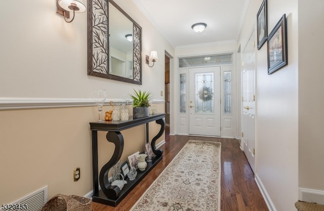 entrance foyer with dark wood-type flooring and crown molding