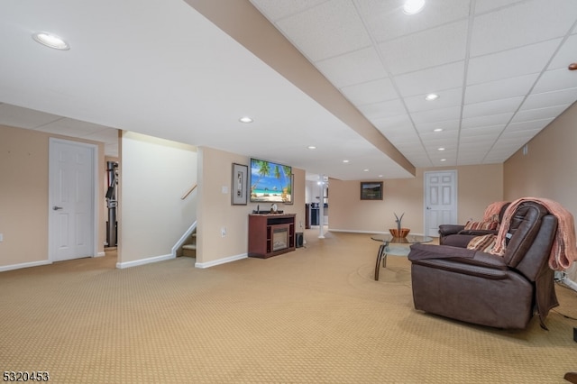 living room featuring a drop ceiling and light carpet