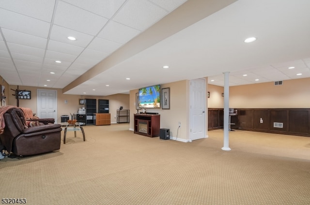 carpeted living room with a paneled ceiling