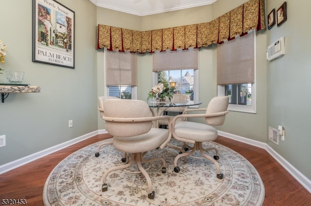 dining space with dark wood-type flooring and ornamental molding