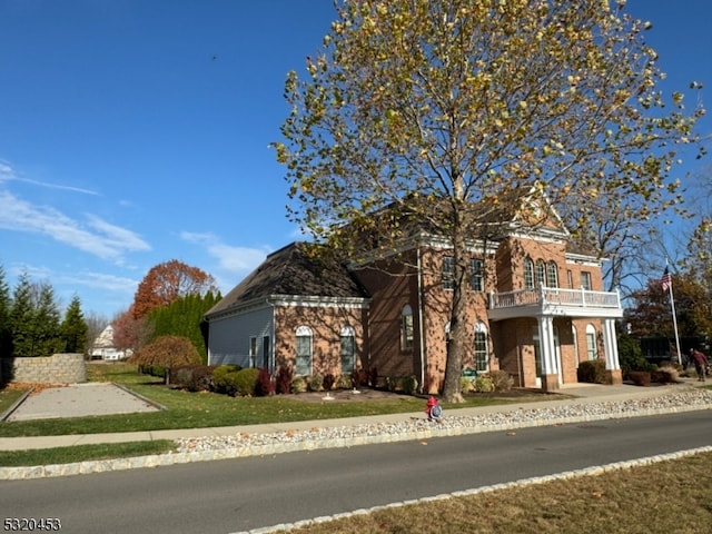 view of front of property with a front yard and a balcony