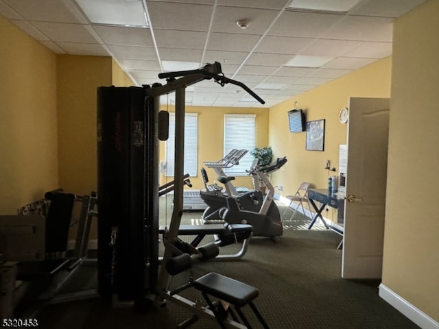 gym with carpet floors and a paneled ceiling