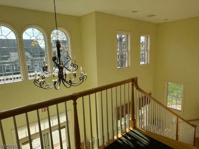 stairway featuring a chandelier