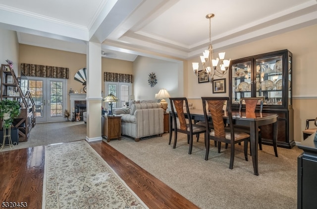 dining area featuring hardwood / wood-style floors, a notable chandelier, a raised ceiling, and ornamental molding