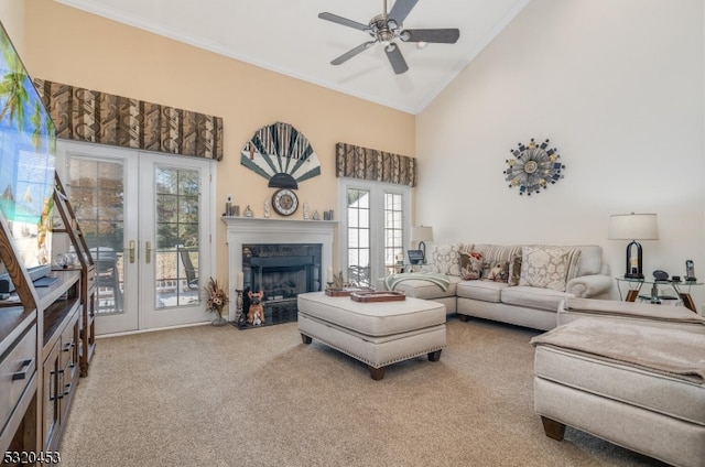 carpeted living room featuring french doors, ceiling fan, crown molding, and high vaulted ceiling