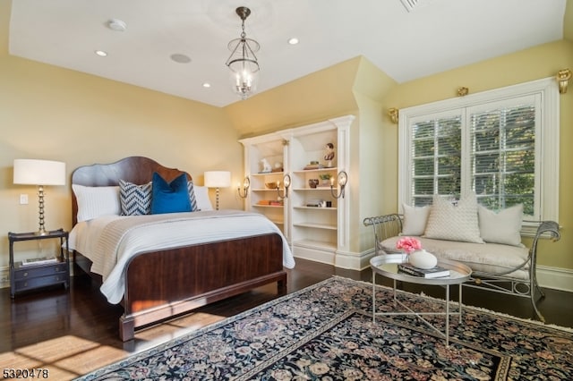 bedroom featuring an inviting chandelier and wood-type flooring