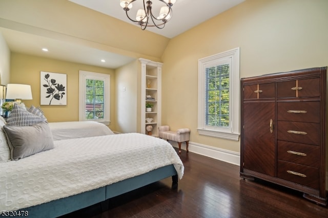 bedroom with ornate columns, vaulted ceiling, dark hardwood / wood-style flooring, and an inviting chandelier