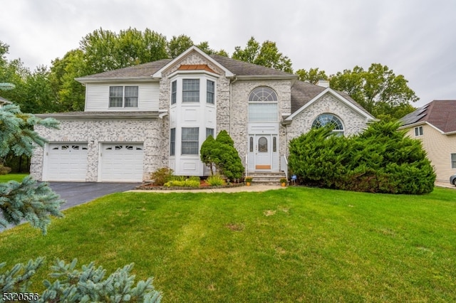 view of front of house featuring a front yard and a garage