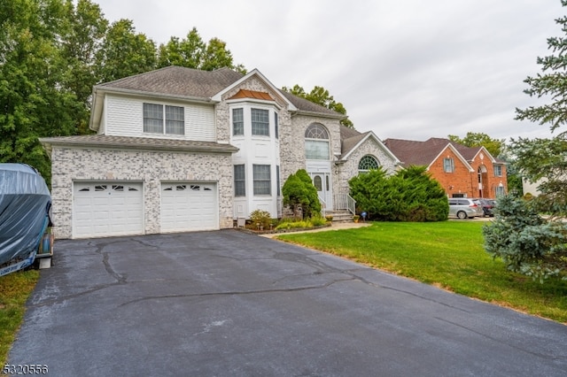 view of front of property featuring a front yard and a garage