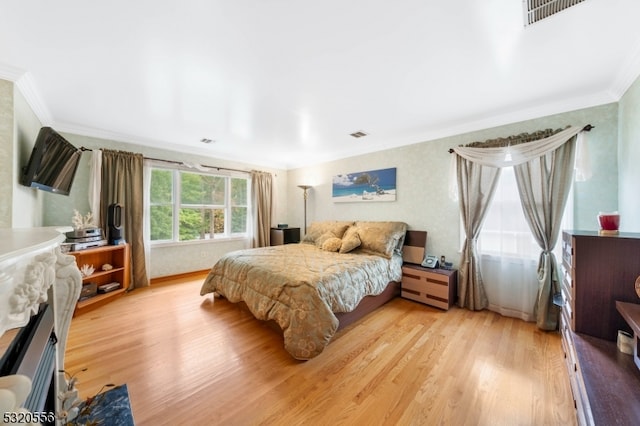 bedroom with crown molding and light hardwood / wood-style flooring