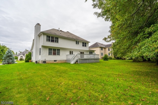 back of house with a wooden deck, a lawn, and central AC unit