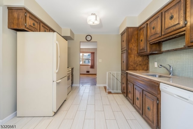 kitchen with white appliances, sink, and tasteful backsplash