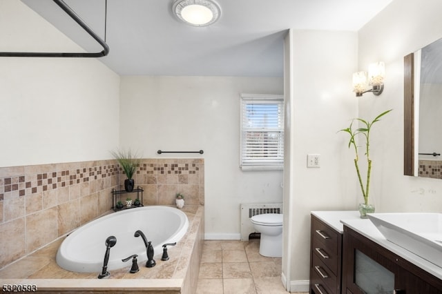 bathroom with radiator heating unit, tiled bath, tile patterned floors, vanity, and toilet