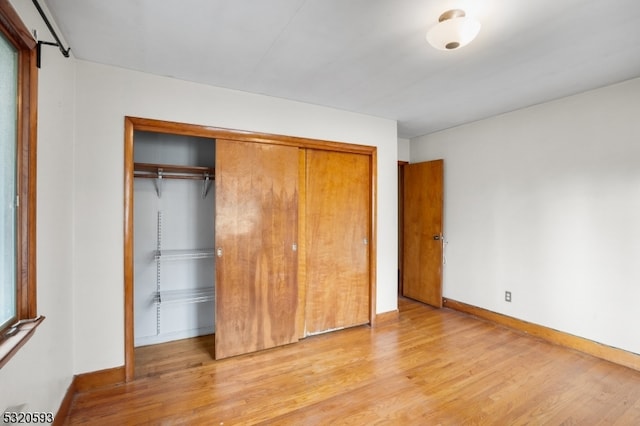 unfurnished bedroom with a closet and light hardwood / wood-style floors