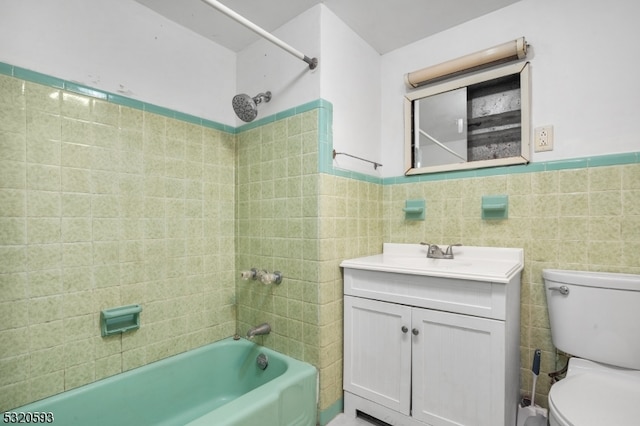 full bathroom with toilet, vanity, tiled shower / bath combo, and tile walls