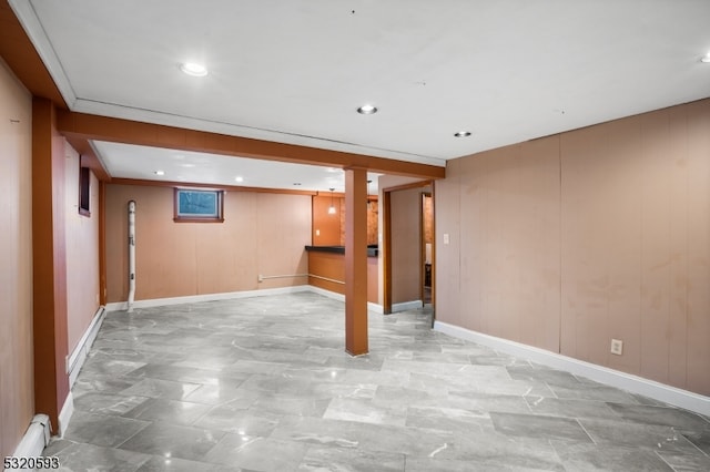 basement with wooden walls and crown molding