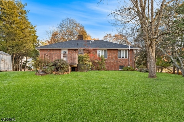 rear view of property with a storage unit, a wooden deck, and a yard