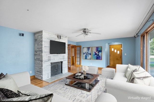 living room with hardwood / wood-style flooring, ceiling fan, and a fireplace