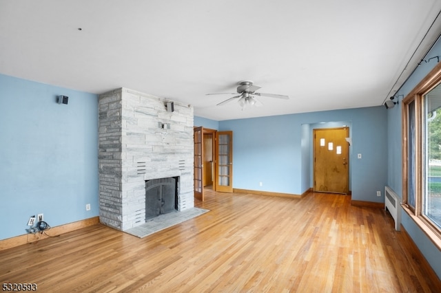 unfurnished living room with a fireplace, light hardwood / wood-style floors, and ceiling fan