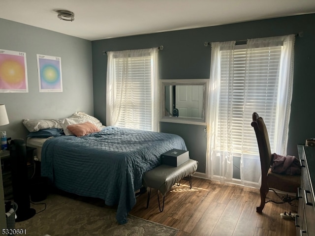 bedroom with wood-type flooring and multiple windows