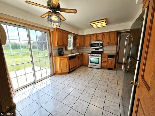 kitchen featuring sink, decorative backsplash, appliances with stainless steel finishes, and ceiling fan