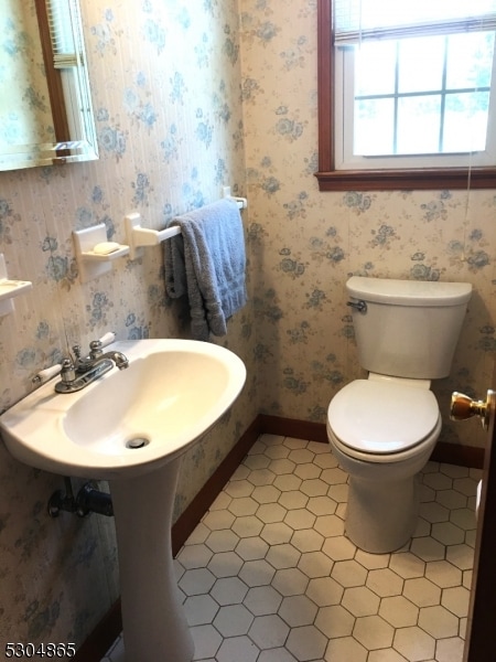 bathroom featuring toilet, sink, and tile patterned floors