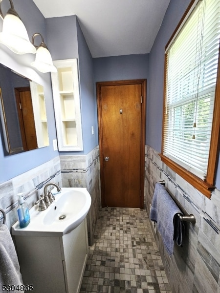 bathroom with vanity and tile walls