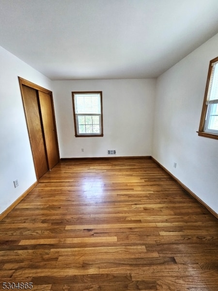 unfurnished bedroom with dark wood-type flooring