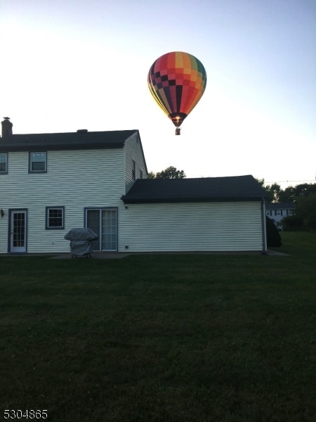 rear view of house featuring a lawn