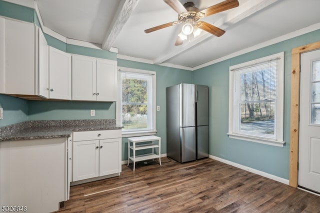 kitchen with white cabinetry, beam ceiling, plenty of natural light, and stainless steel fridge