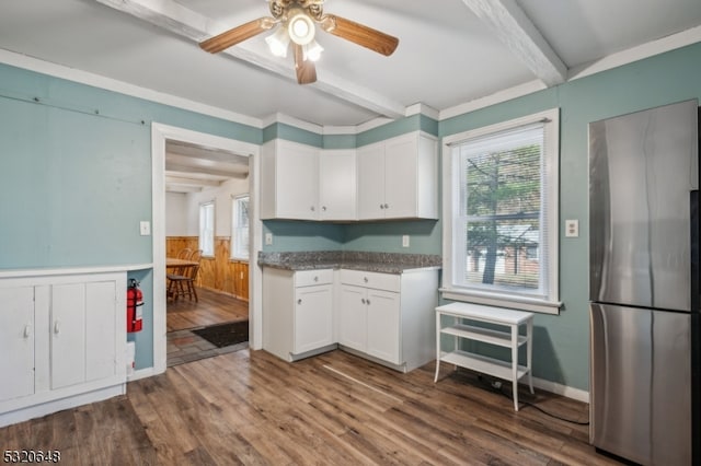 kitchen with white cabinetry, beam ceiling, stainless steel refrigerator, and dark wood-type flooring