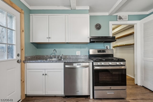 kitchen featuring dark wood-type flooring, range hood, sink, white cabinetry, and appliances with stainless steel finishes